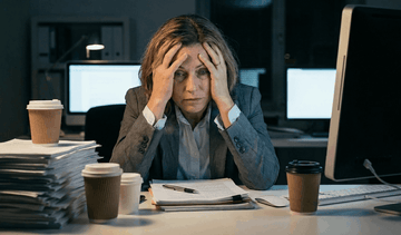 woman with head in hands stressed at work