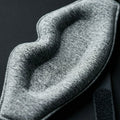 Close-up of a textured gray fabric of sleep eye mask with a dark background